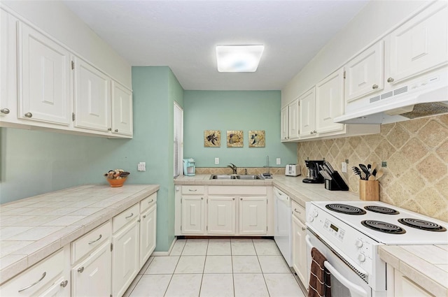 kitchen featuring tile countertops, under cabinet range hood, white appliances, white cabinets, and decorative backsplash