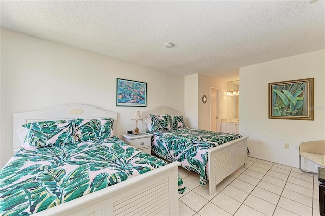 bedroom with connected bathroom, a textured ceiling, and light tile patterned flooring