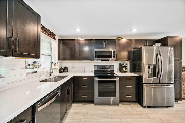 kitchen featuring tasteful backsplash, light hardwood / wood-style floors, appliances with stainless steel finishes, and sink