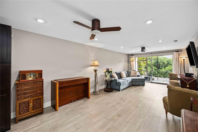 living room with light wood-type flooring and ceiling fan