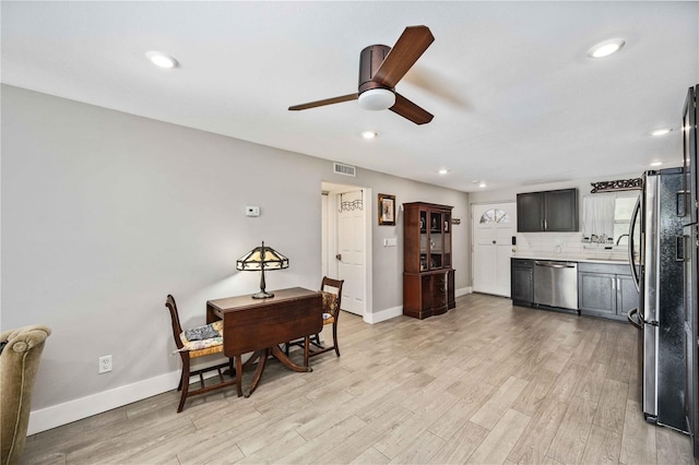 kitchen with stainless steel appliances, light hardwood / wood-style floors, tasteful backsplash, and ceiling fan