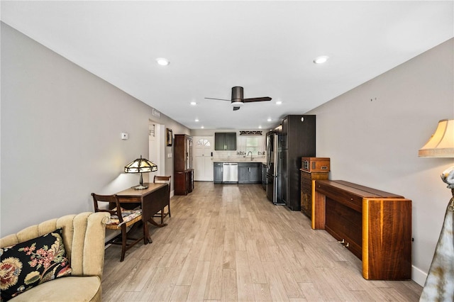 living room with light hardwood / wood-style floors, sink, and ceiling fan