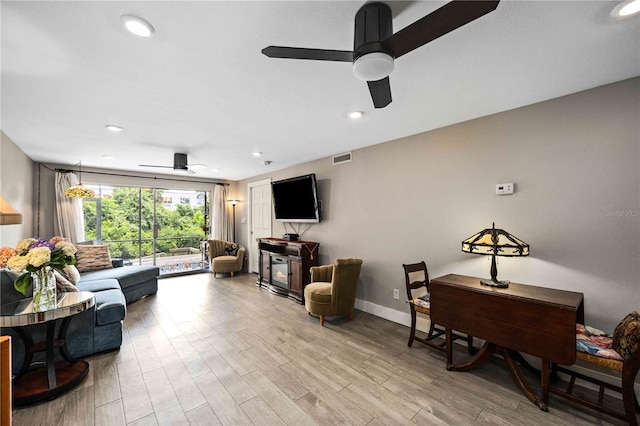 living room with light hardwood / wood-style flooring and ceiling fan