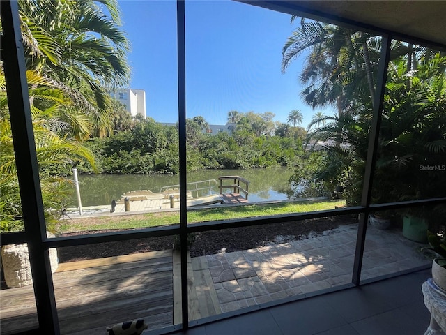 unfurnished sunroom featuring a water view