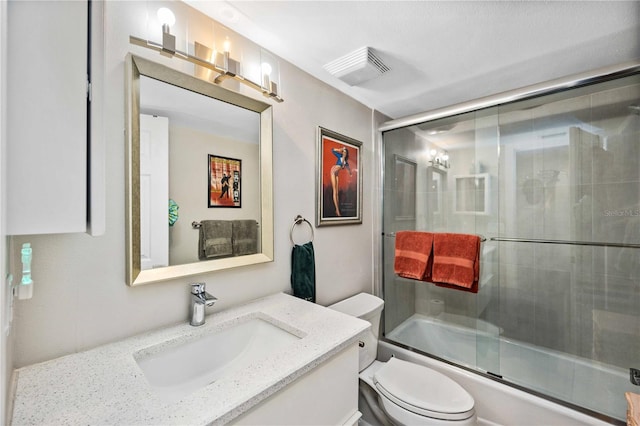 full bathroom with vanity, shower / bath combination with glass door, and toilet