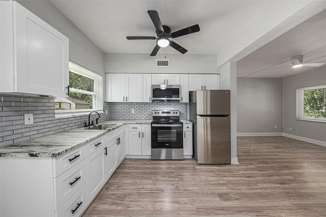 kitchen featuring light wood-type flooring, sink, ceiling fan, appliances with stainless steel finishes, and white cabinets