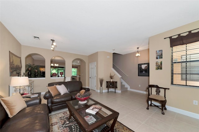 tiled living room featuring an inviting chandelier