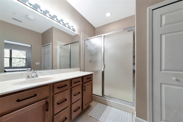 bathroom with an enclosed shower, vanity, and tile patterned floors