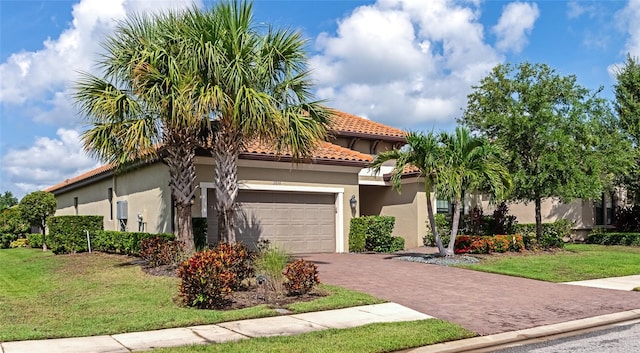 mediterranean / spanish home with a garage and a front lawn