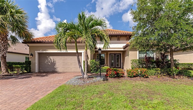 mediterranean / spanish house featuring a garage and a front yard