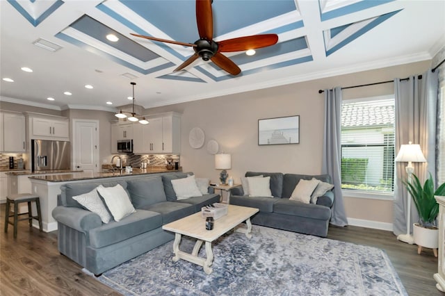 living room with ceiling fan, dark hardwood / wood-style floors, coffered ceiling, and ornamental molding