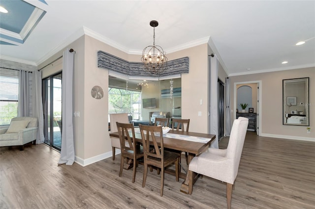 dining space featuring hardwood / wood-style flooring, crown molding, a wealth of natural light, and an inviting chandelier