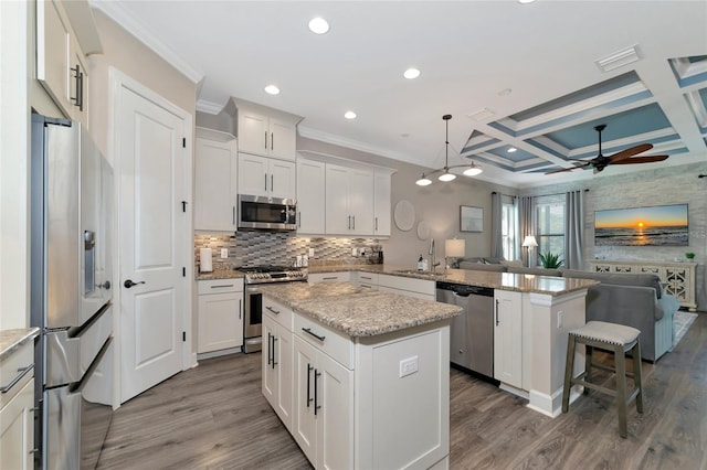 kitchen featuring stainless steel appliances, hardwood / wood-style floors, a kitchen island, beam ceiling, and coffered ceiling