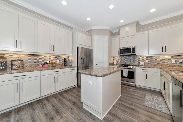 kitchen featuring appliances with stainless steel finishes, backsplash, white cabinetry, and hardwood / wood-style floors