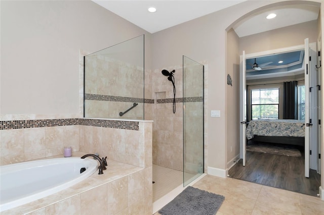 bathroom with independent shower and bath, hardwood / wood-style flooring, and ceiling fan