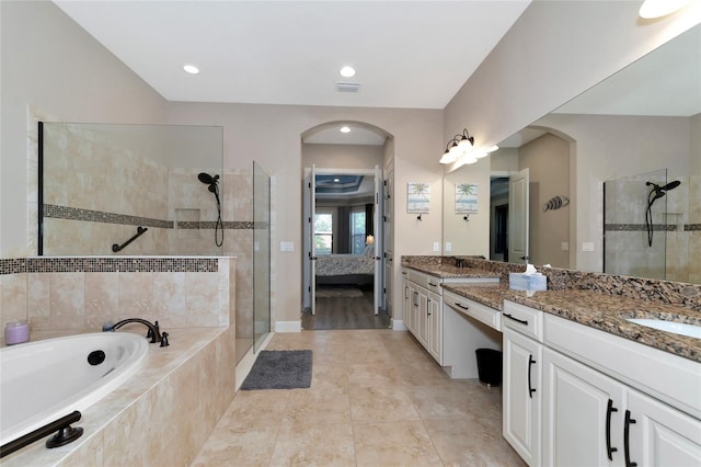 bathroom featuring dual vanity, shower with separate bathtub, and tile patterned flooring