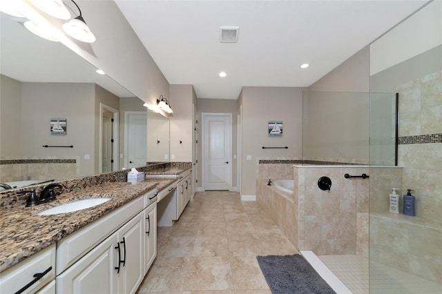 bathroom featuring double vanity, plus walk in shower, and tile patterned floors