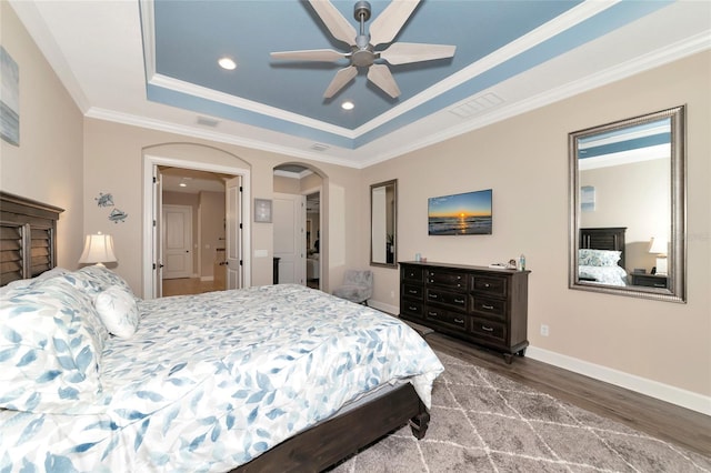 bedroom featuring wood-type flooring, ceiling fan, a raised ceiling, and crown molding