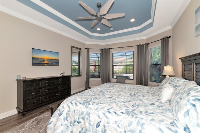 bedroom with dark hardwood / wood-style flooring, ceiling fan, a raised ceiling, and crown molding