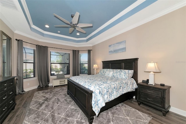 bedroom featuring ornamental molding, ceiling fan, dark hardwood / wood-style floors, and a tray ceiling