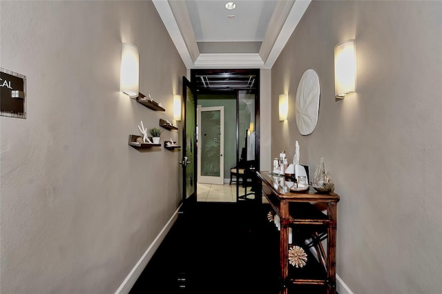 hallway featuring a tray ceiling and tile patterned floors