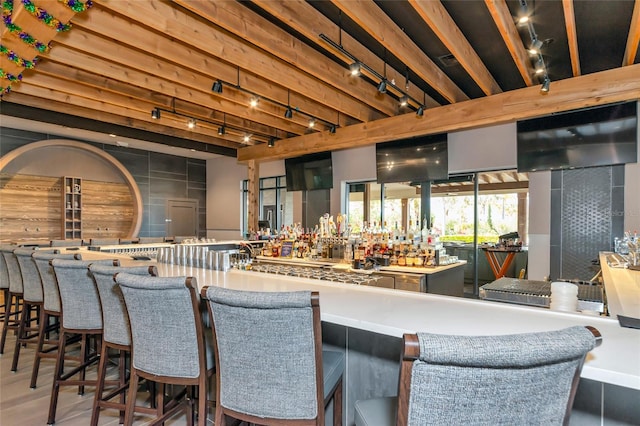 bar featuring beam ceiling and rail lighting