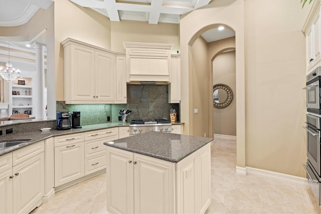 kitchen with range, coffered ceiling, light tile patterned floors, and tasteful backsplash