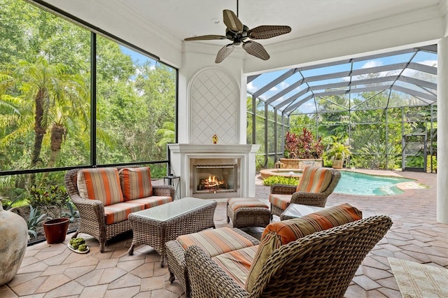 sunroom featuring plenty of natural light, ceiling fan, and an outdoor fireplace