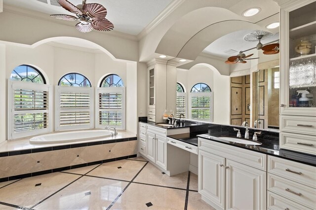 bathroom featuring a relaxing tiled tub, plenty of natural light, vanity, and ceiling fan