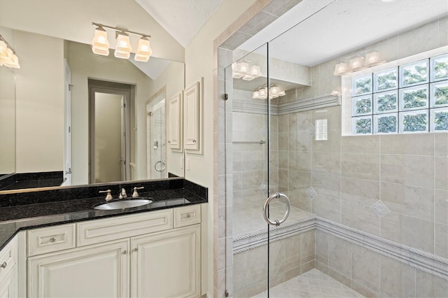 bathroom featuring vaulted ceiling, vanity, and an enclosed shower