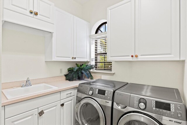 clothes washing area with sink, cabinets, and washer and dryer