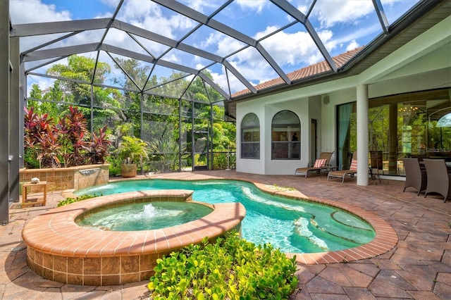 view of swimming pool featuring an in ground hot tub, pool water feature, glass enclosure, and a patio area