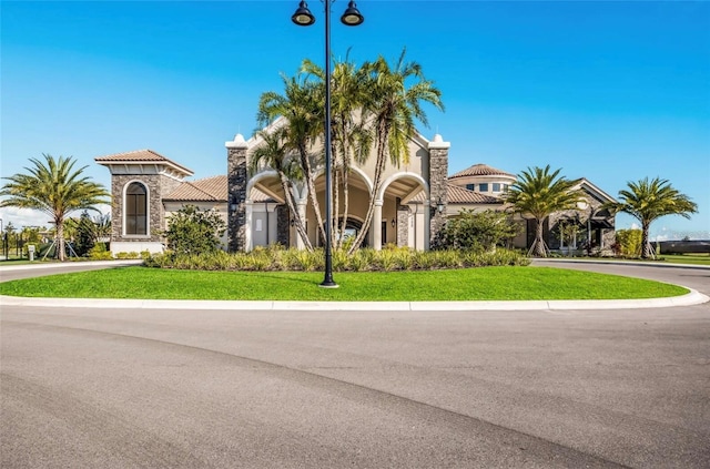 view of front of home with a tiled roof, a front lawn, and stucco siding