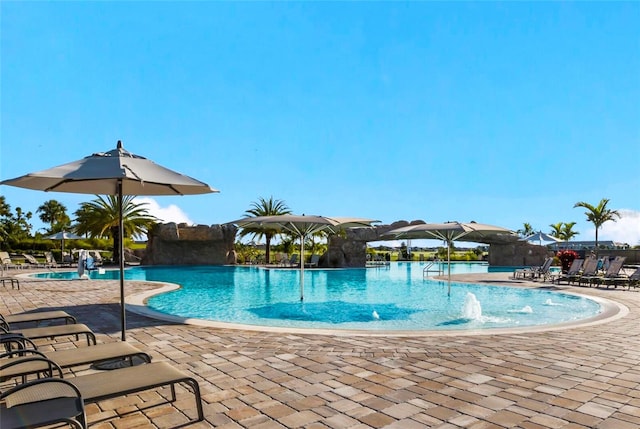 view of swimming pool featuring pool water feature and a patio