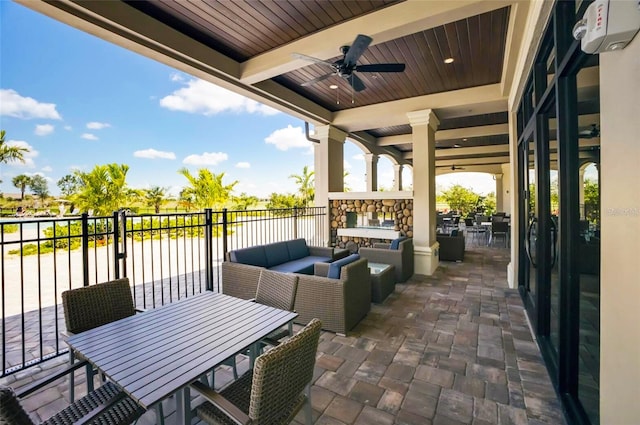 view of patio / terrace with an outdoor living space with a fireplace and ceiling fan