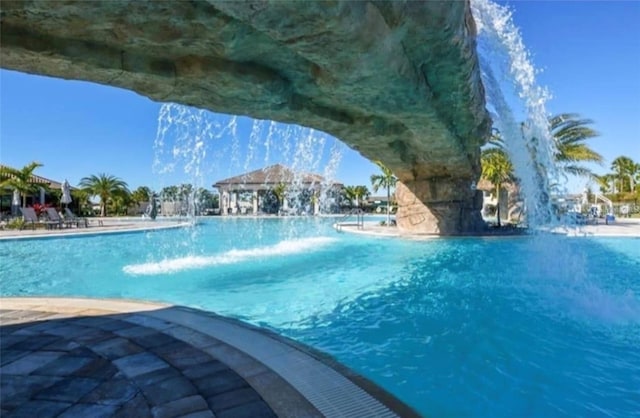 view of swimming pool with pool water feature