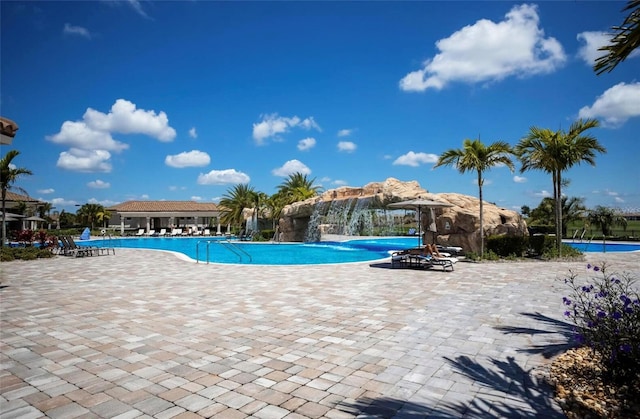 view of swimming pool featuring pool water feature and a patio