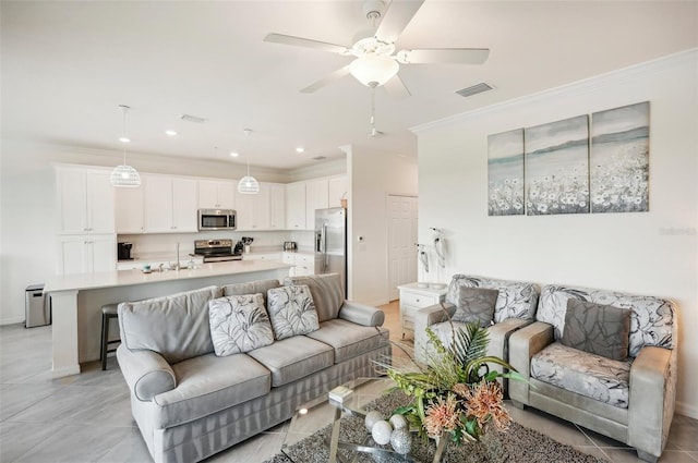 living room with light tile patterned floors, ceiling fan, ornamental molding, and sink