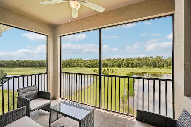 unfurnished sunroom featuring a water view and ceiling fan