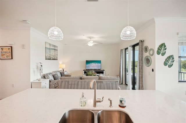 kitchen with ceiling fan, hanging light fixtures, crown molding, and sink