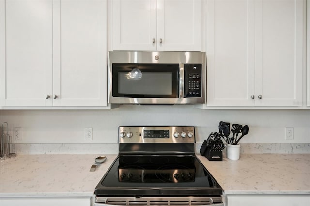 kitchen with white cabinets, light stone countertops, and appliances with stainless steel finishes