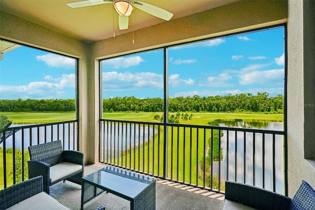 sunroom featuring a water view and ceiling fan