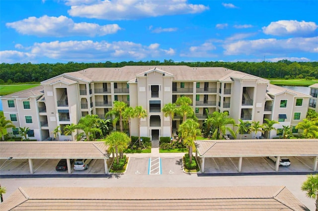 view of property featuring covered and uncovered parking