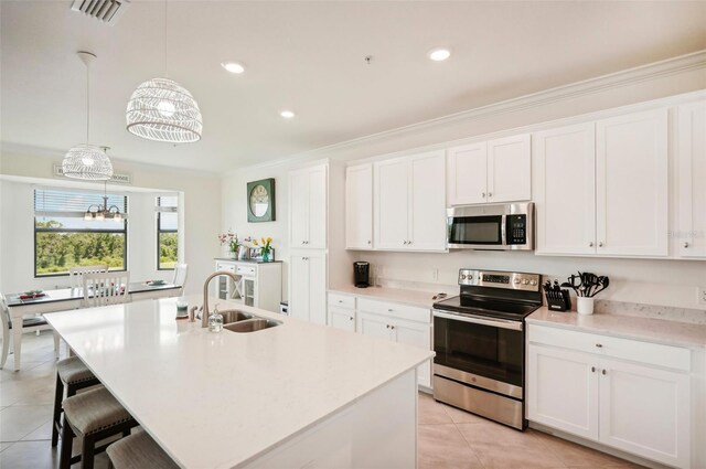 kitchen with light tile patterned floors, a sink, visible vents, appliances with stainless steel finishes, and an island with sink