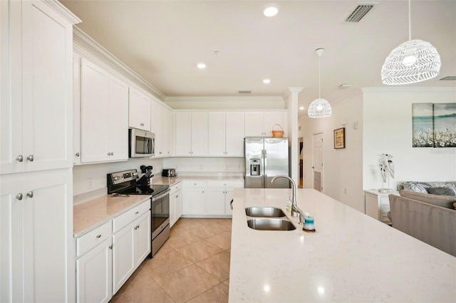 kitchen featuring light tile patterned floors, white cabinets, ornamental molding, stainless steel appliances, and a sink