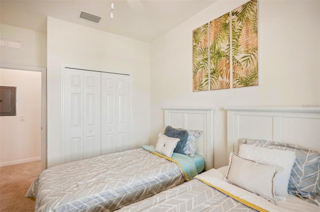 carpeted bedroom with a closet, visible vents, and electric panel