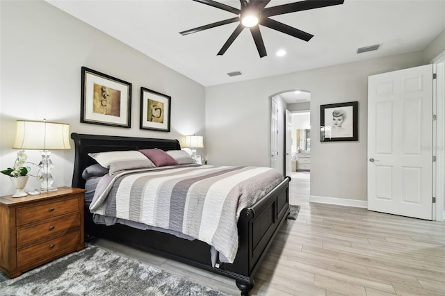 bedroom with ceiling fan, ensuite bathroom, and light hardwood / wood-style flooring