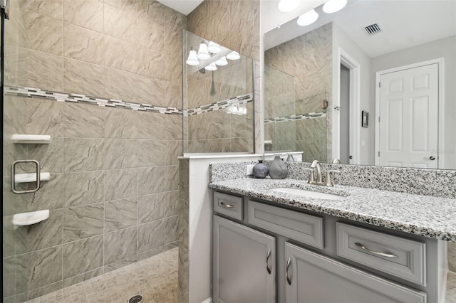 bathroom with vanity and tiled shower