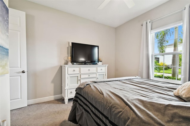 bedroom featuring light carpet, multiple windows, and ceiling fan