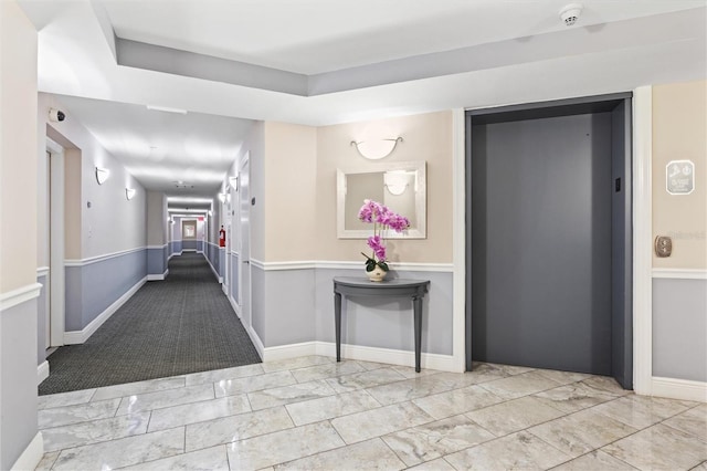 hall featuring elevator and light tile patterned floors